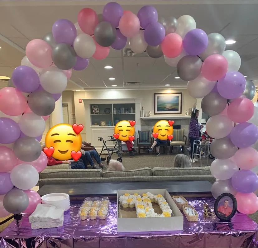 Pink, lavender, pearl and gray balloon arch framing a table of cupcakes on a purple tablecloth