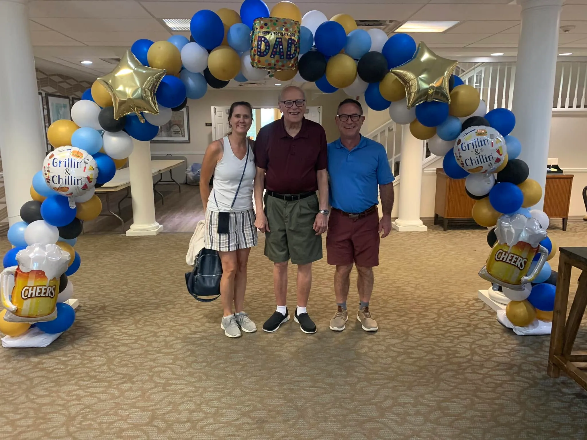 Father's Day balloon arch in royal blue, light blue, gold, black and white with a DAD foil, gold stars and Grillin' and Chillin' balloons