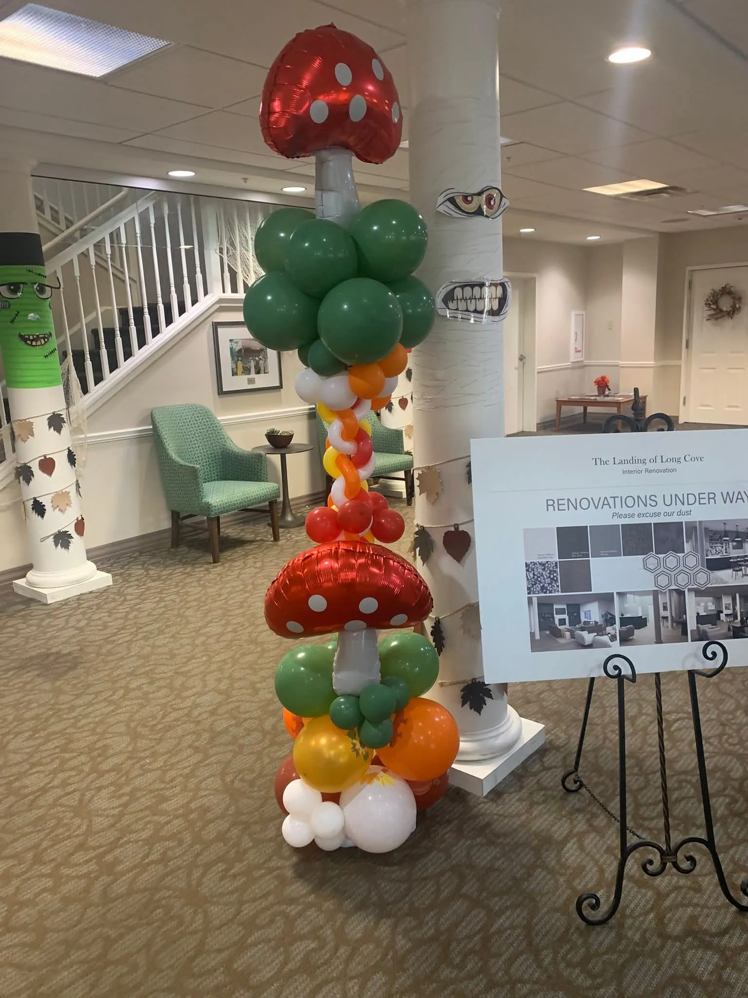Balloon column with red polka-dot mushroom foil balloons, green clusters and orange, yellow and white balloons