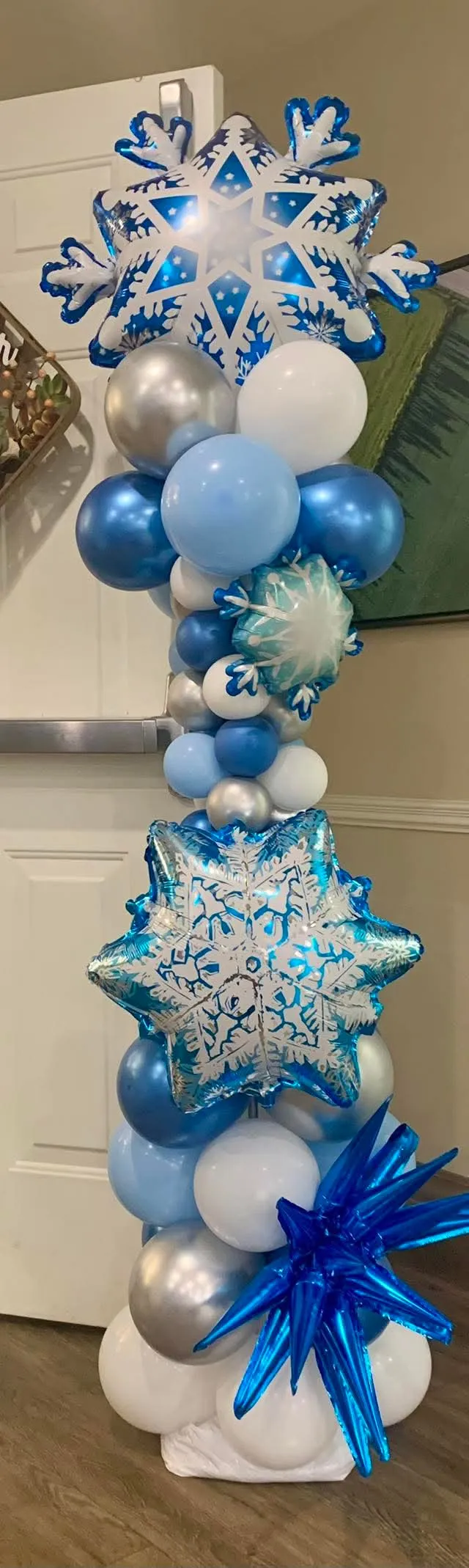 Tall blue, white and silver balloon column topped with snowflake balloons